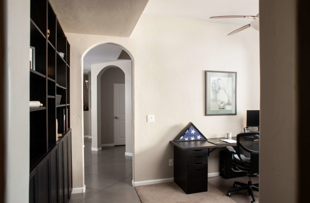 home office remodeled with built in bookshelves and an arched doorway