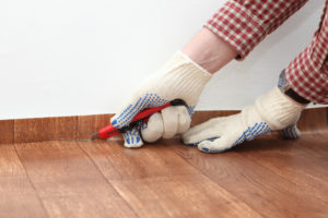 Worker installing linoleum flooring